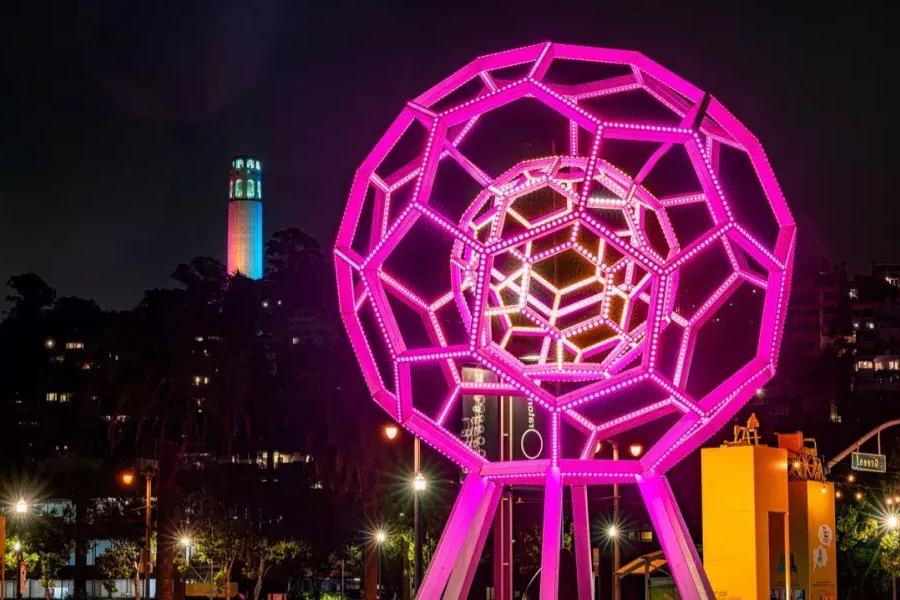 Buckyball brille au premier plan tandis que Coit Tower brille au loin.