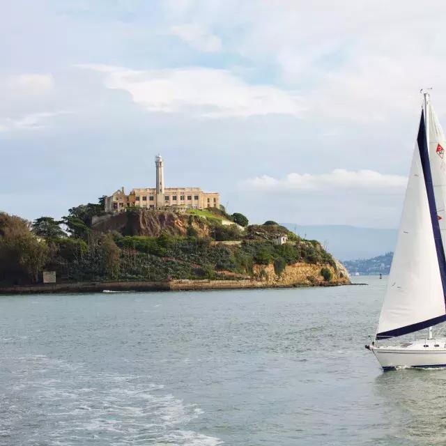 Una barca a vela passa davanti all'isola di Alcatraz a San Francisco.